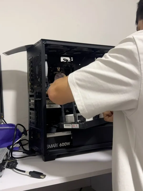 Persona de camisa blanca haciendo mantenimiento a una torre de computador abierta sobre un escritorio